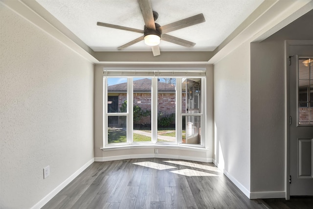 empty room featuring ceiling fan, dark hardwood / wood-style flooring, and a textured ceiling