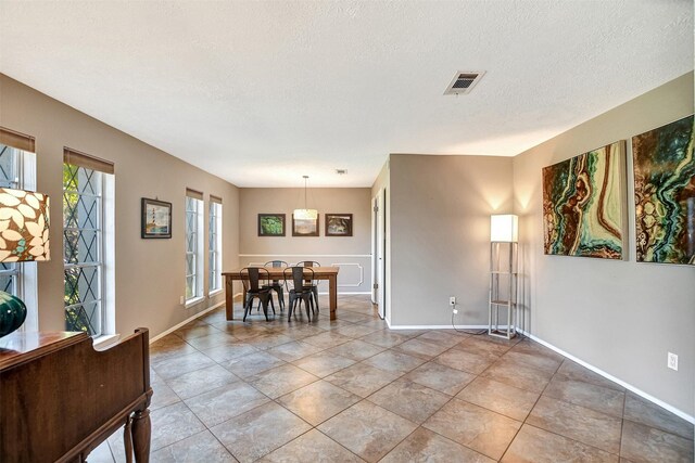 tiled dining room with a textured ceiling