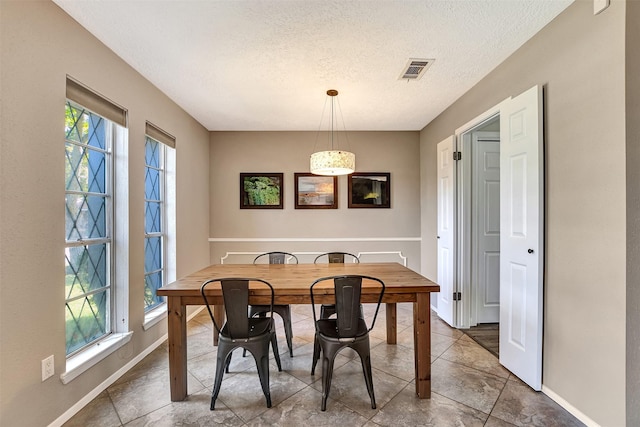 dining space with a healthy amount of sunlight and a textured ceiling