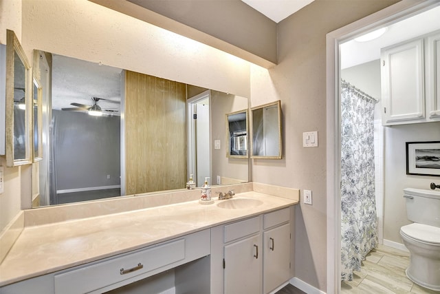 bathroom featuring ceiling fan, vanity, a textured ceiling, and toilet