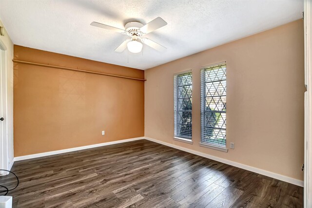 spare room with a textured ceiling, ceiling fan, and dark wood-type flooring