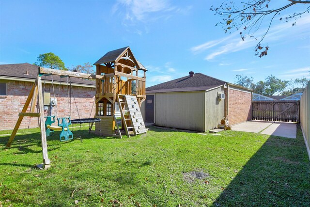 view of playground featuring a shed, a yard, and a patio