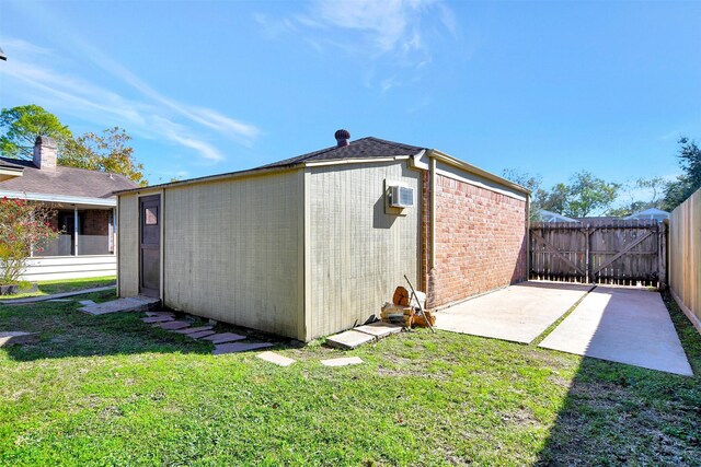 view of outdoor structure with a yard and a wall unit AC