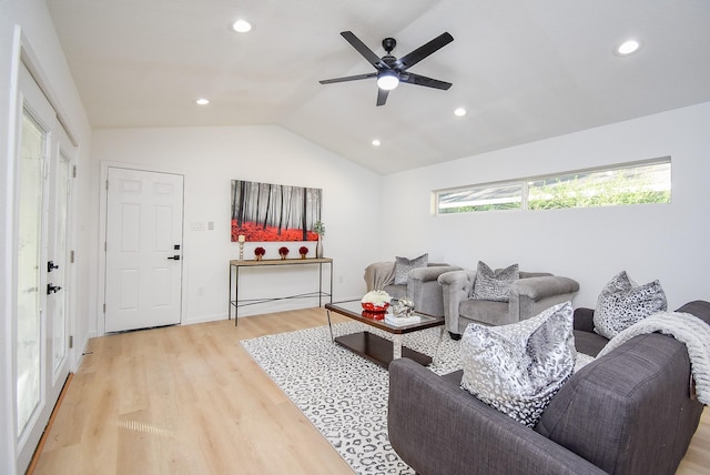 living room featuring vaulted ceiling, light hardwood / wood-style flooring, and ceiling fan