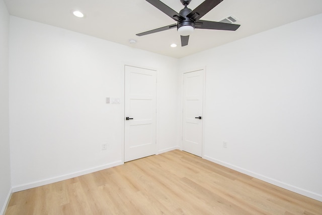 empty room with ceiling fan and light hardwood / wood-style floors