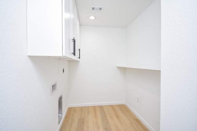 clothes washing area featuring cabinets, washer hookup, light hardwood / wood-style flooring, and electric dryer hookup