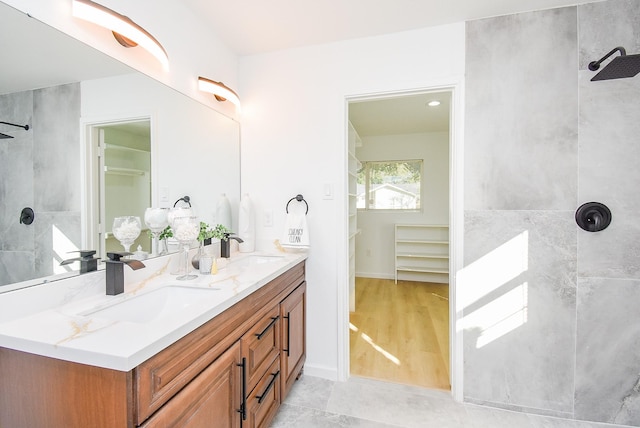 bathroom featuring vanity, wood-type flooring, and tiled shower