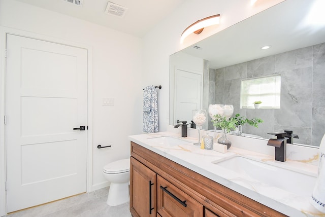 bathroom with tile patterned flooring, vanity, and toilet