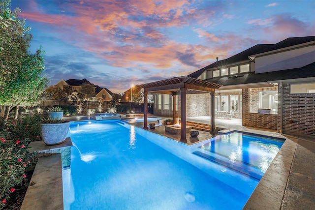 pool at dusk with an in ground hot tub, a patio, pool water feature, and a pergola