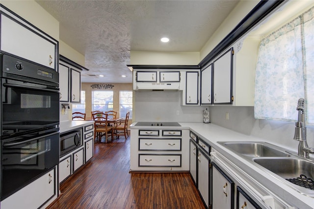 kitchen with black appliances, white cabinets, sink, a textured ceiling, and dark hardwood / wood-style flooring