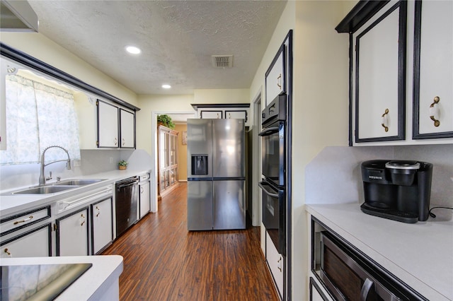 kitchen featuring a textured ceiling, sink, dark hardwood / wood-style floors, and appliances with stainless steel finishes