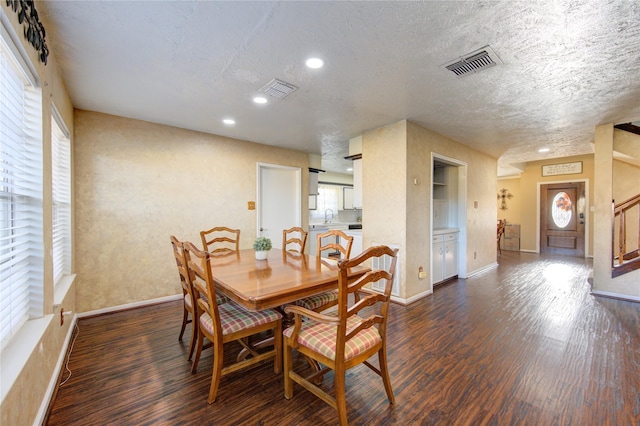 dining room with a textured ceiling, dark hardwood / wood-style floors, and sink