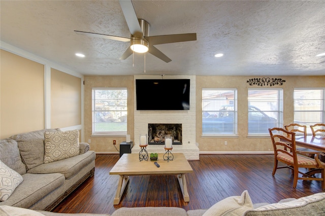 living room with plenty of natural light, dark wood-type flooring, and a textured ceiling