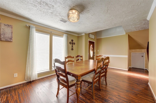 dining room featuring dark hardwood / wood-style floors, ornamental molding, and a textured ceiling