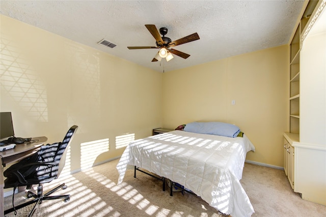 bedroom featuring light carpet, a textured ceiling, and ceiling fan