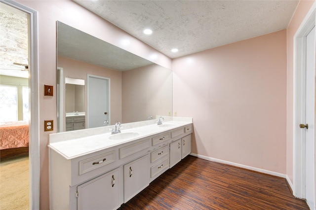 bathroom featuring vanity, hardwood / wood-style floors, and a textured ceiling