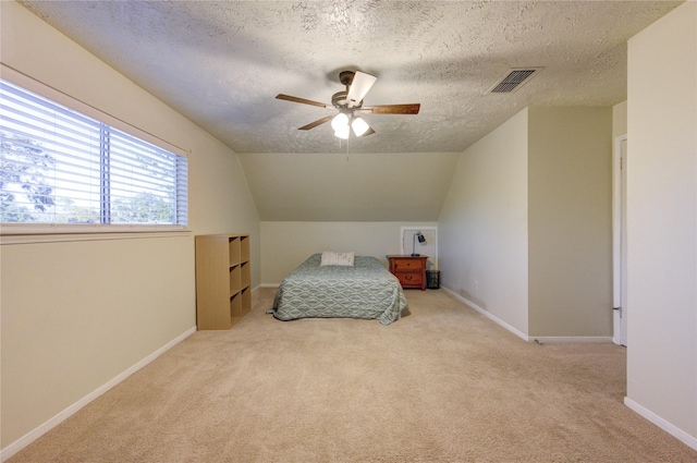 bedroom featuring a textured ceiling, ceiling fan, lofted ceiling, and light carpet