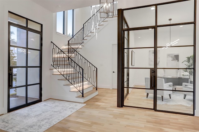 foyer entrance featuring an inviting chandelier and light wood-type flooring