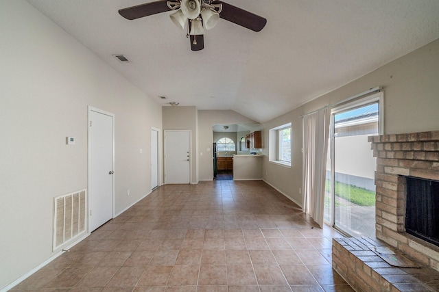 unfurnished living room with ceiling fan, light tile patterned flooring, a fireplace, and vaulted ceiling