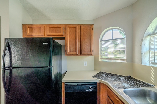 kitchen featuring black appliances, sink, and a textured ceiling