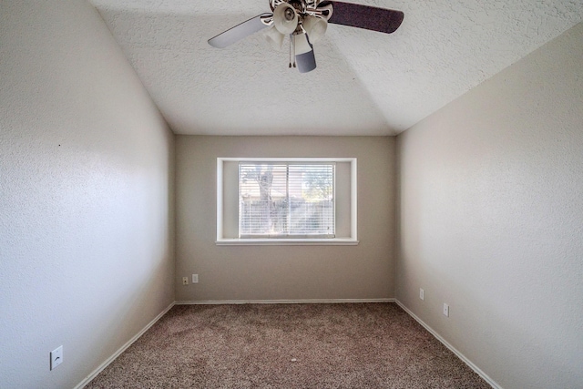 carpeted empty room with ceiling fan, lofted ceiling, and a textured ceiling