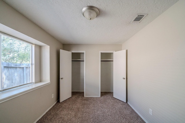 unfurnished bedroom with carpet and a textured ceiling