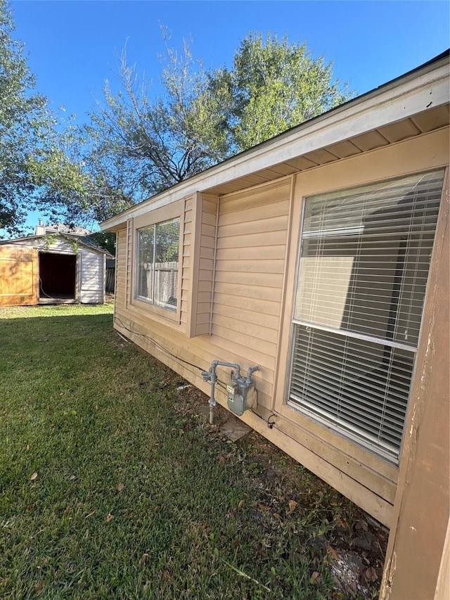 view of side of property with a yard and a shed