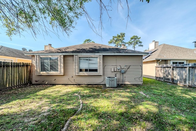 back of house with a lawn and central AC