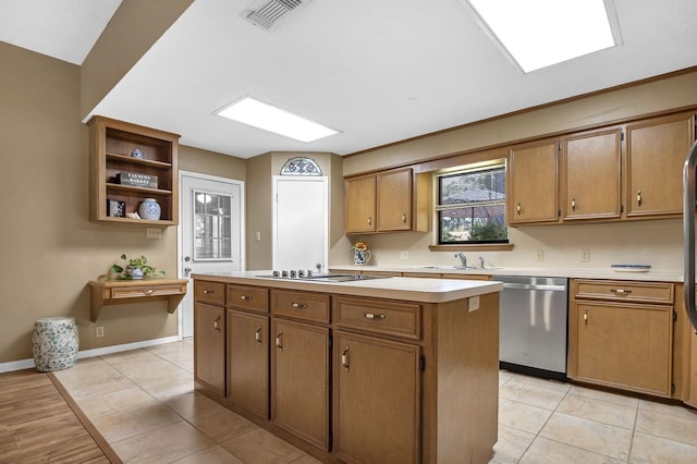 kitchen featuring sink, light tile patterned floors, stainless steel dishwasher, stovetop, and a kitchen island