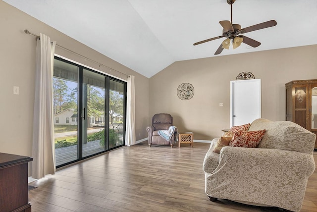 living area featuring ceiling fan, wood-type flooring, and vaulted ceiling