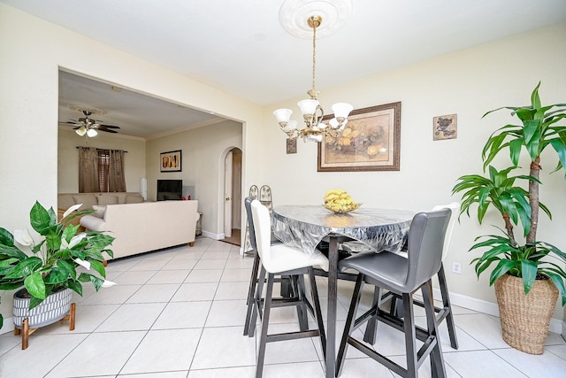 tiled dining room with ceiling fan with notable chandelier and crown molding