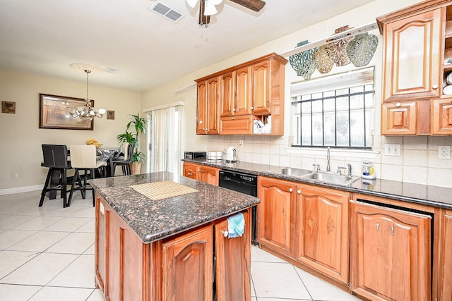 kitchen with pendant lighting, sink, a kitchen island, and a healthy amount of sunlight