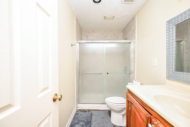 bathroom featuring a textured ceiling, vanity, tile patterned flooring, toilet, and a shower with shower door