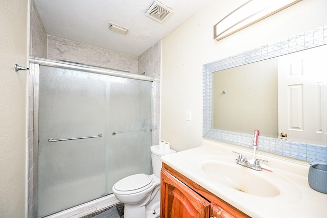 bathroom featuring a textured ceiling, vanity, toilet, and walk in shower