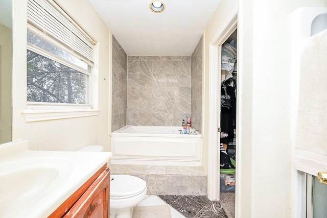 bathroom with vanity, toilet, and a tub