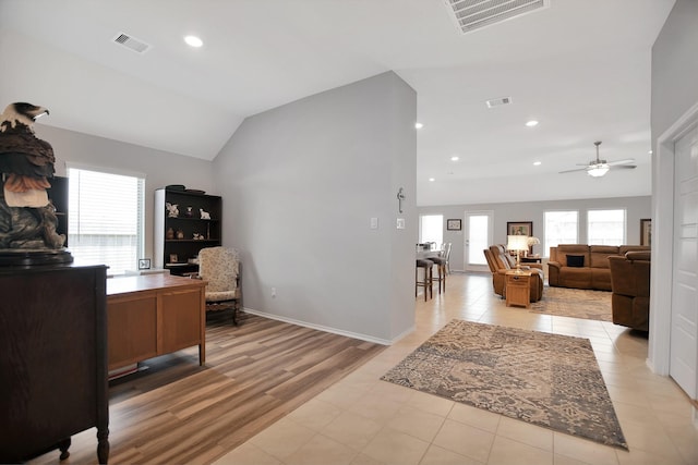 office space featuring ceiling fan, light wood-type flooring, and vaulted ceiling