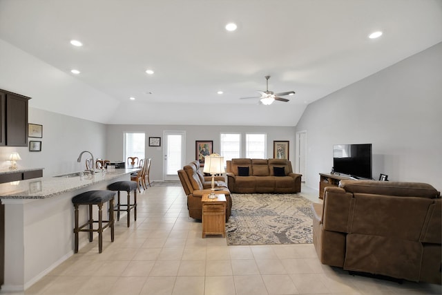 living room featuring ceiling fan, light tile patterned flooring, lofted ceiling, and sink