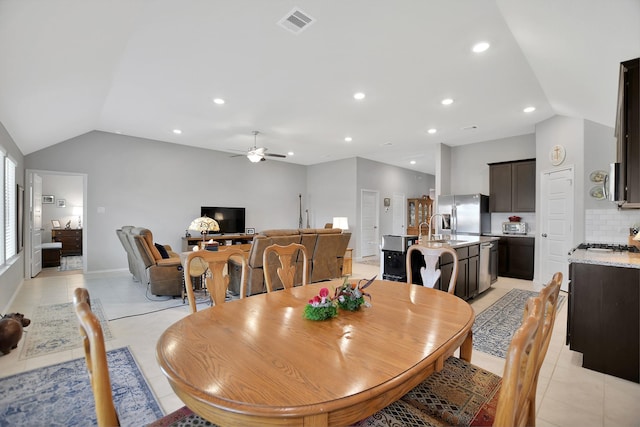 tiled dining room featuring vaulted ceiling, ceiling fan, and sink