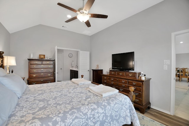 bedroom with ceiling fan, wood-type flooring, lofted ceiling, and ensuite bath