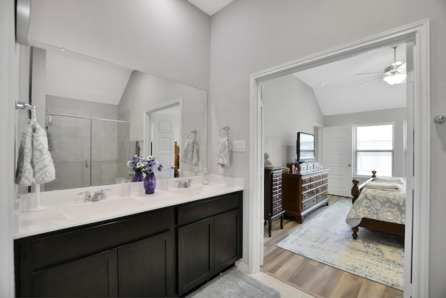 bathroom featuring ceiling fan, walk in shower, wood-type flooring, vaulted ceiling, and vanity