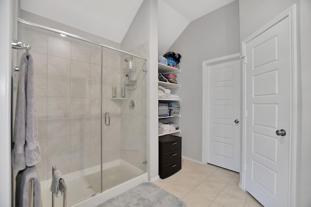 bathroom with tile patterned flooring, vaulted ceiling, and an enclosed shower