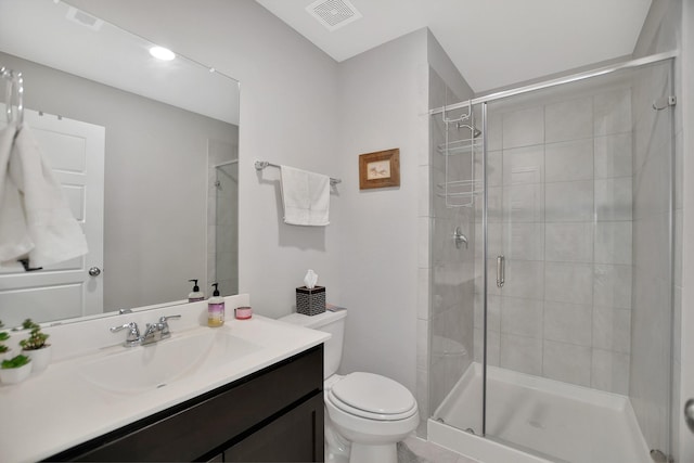 bathroom featuring vanity, toilet, and a shower with shower door