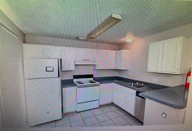 kitchen featuring light tile patterned floors, white appliances, white cabinetry, and sink