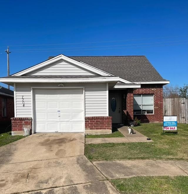 ranch-style house with a garage and a front lawn