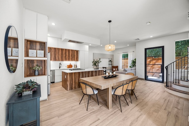 dining area featuring light wood-type flooring and sink