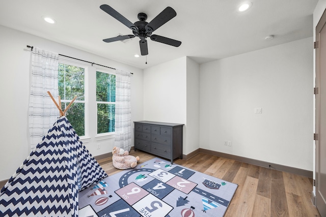 game room with ceiling fan and light wood-type flooring