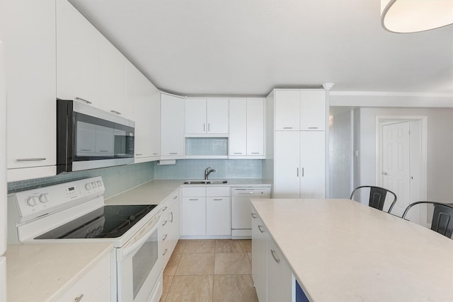 kitchen with white appliances, white cabinets, sink, decorative backsplash, and light tile patterned flooring