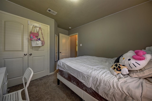 carpeted bedroom featuring a closet and a textured ceiling