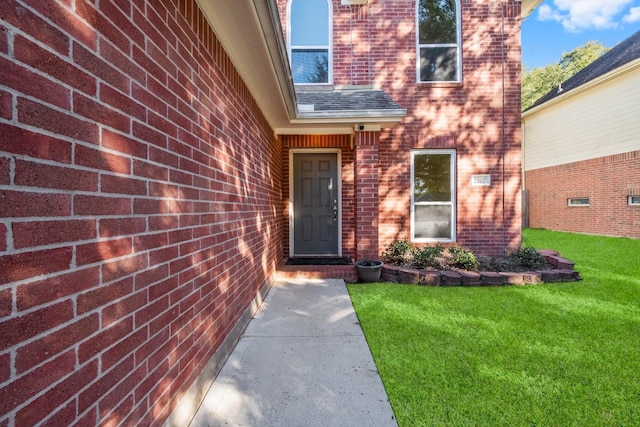 doorway to property featuring a lawn