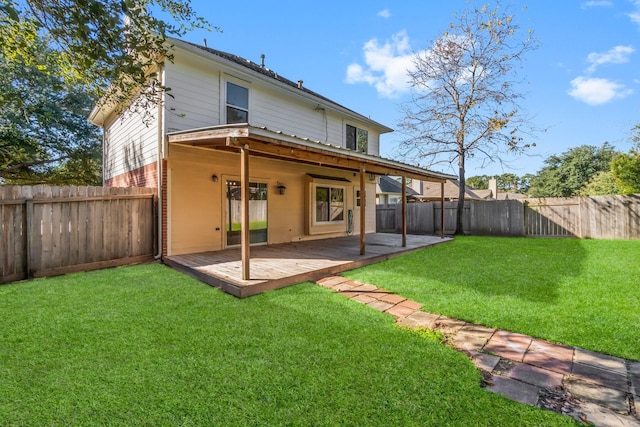 back of property with a deck and a yard